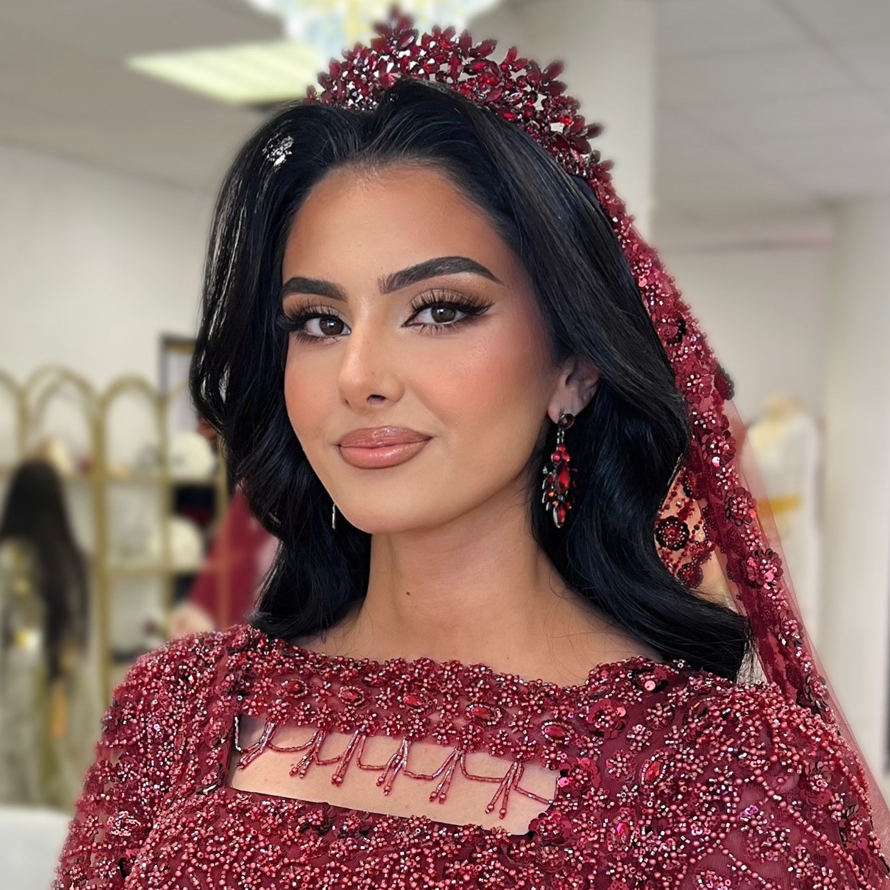Novia con maquillaje sofisticado e intenso de Sanaa — mirada trabajada, vestido rojo bordado