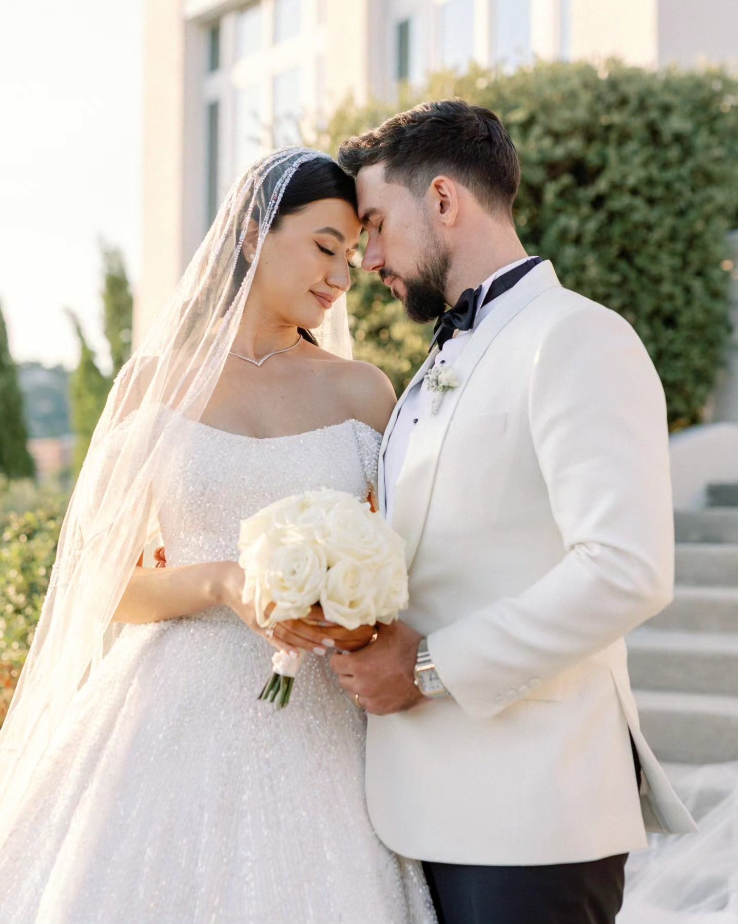 Gulnoza et Romain, front contre front, bouquet de roses blanches