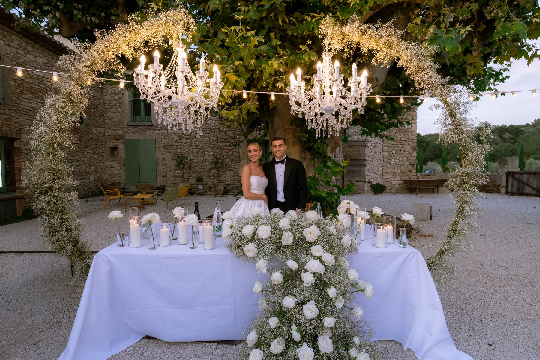 Les mariés à leur table, sous les lustres du Domaine Terre Elais